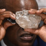 Botswana President Mokgweetsi Masisi examines a large diamond discovered in Botswana at his office in Gaborone. PHOTO | France24