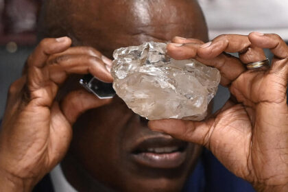 Botswana President Mokgweetsi Masisi examines a large diamond discovered in Botswana at his office in Gaborone. PHOTO | France24