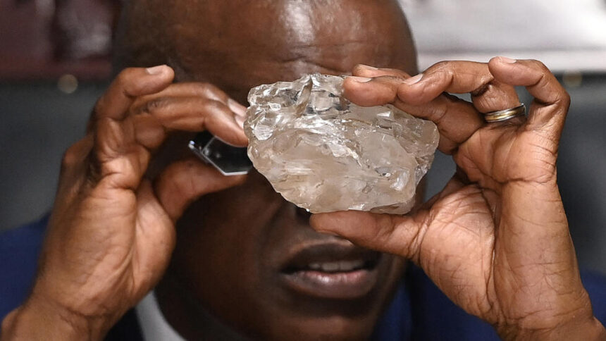 Botswana President Mokgweetsi Masisi examines a large diamond discovered in Botswana at his office in Gaborone. PHOTO | France24